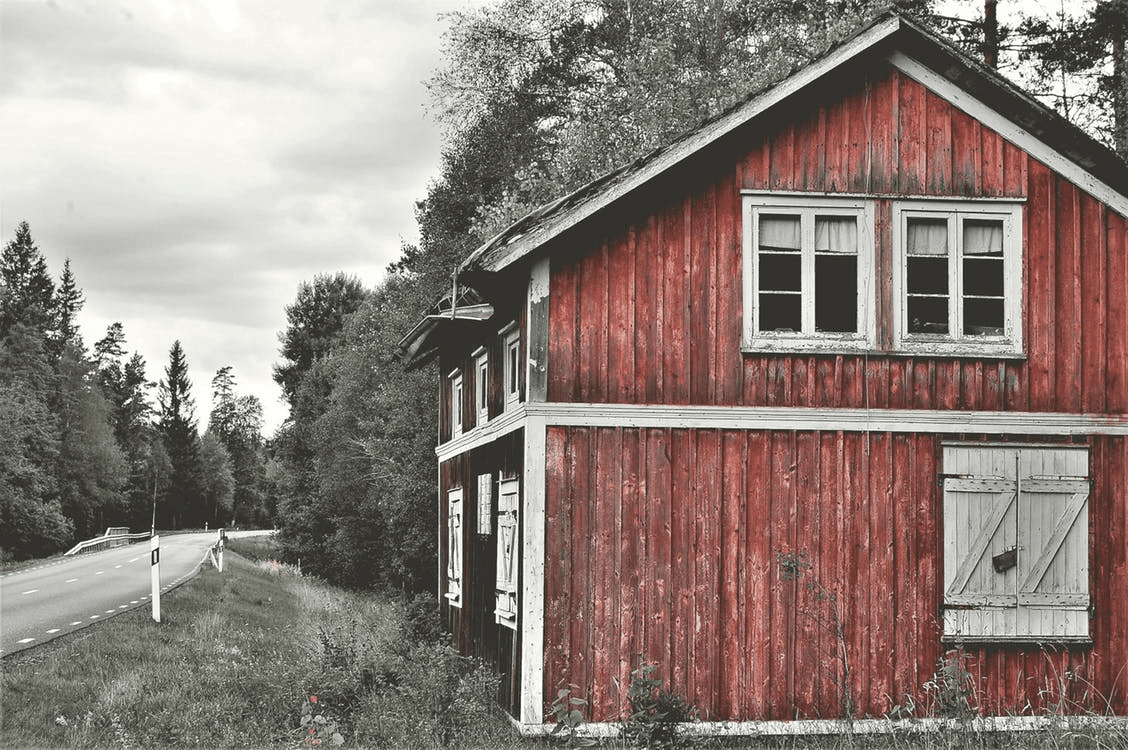 A red barn with a lot of windows on the side.