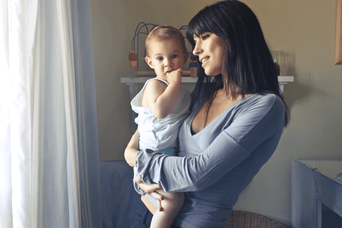 A woman holding a baby in her arms.