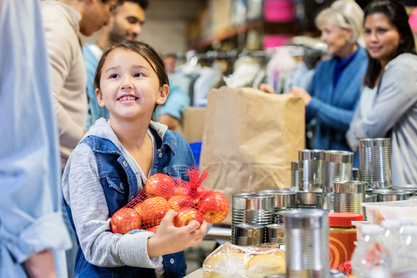 A girl holding apples in her hand at the grocery store.