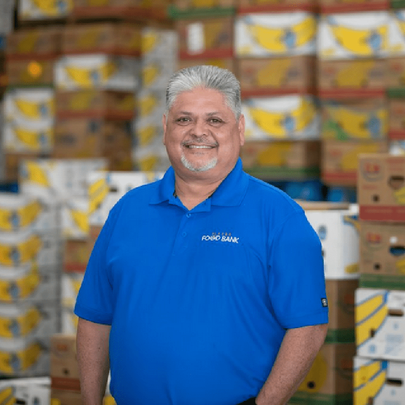 A man standing in front of boxes of food.