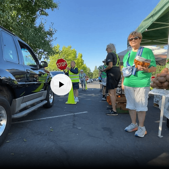 A woman standing next to an suv in front of a market.